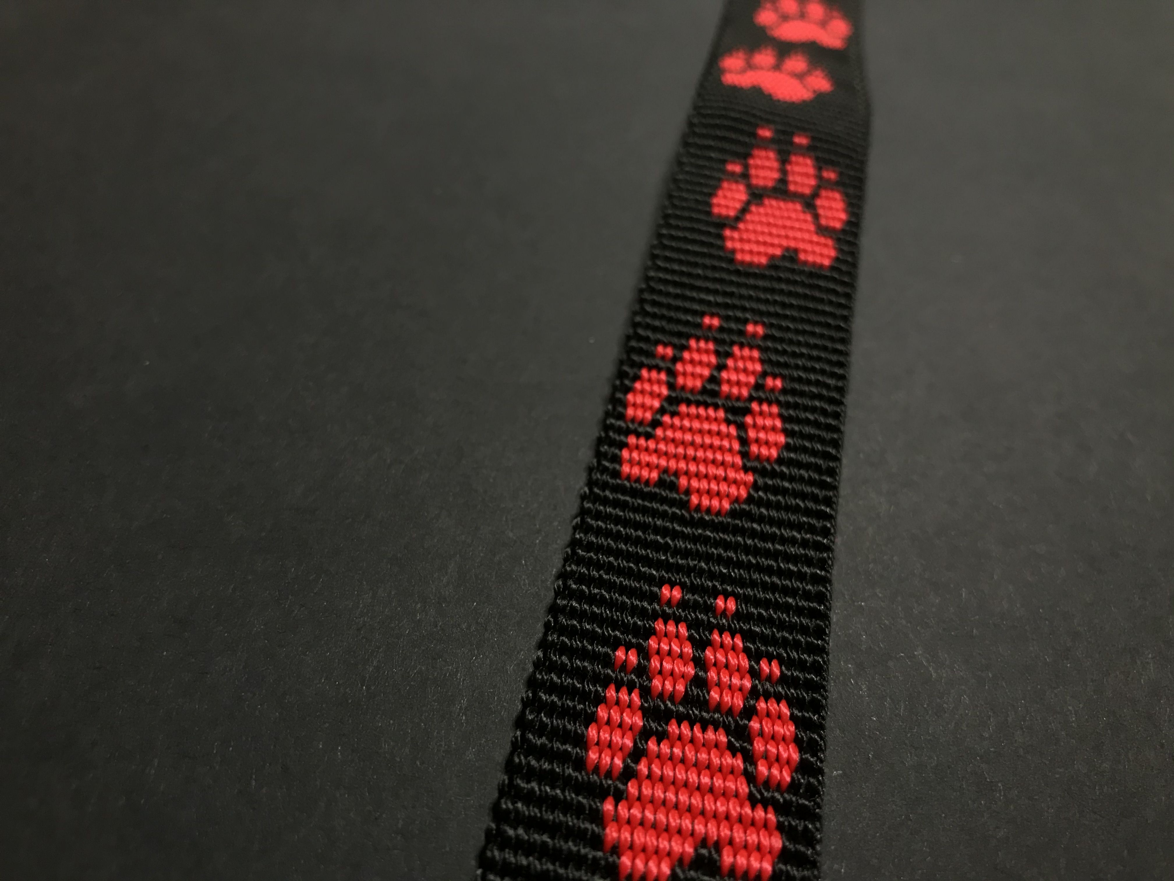 Palkar vodítko z popruhu pre psov 150 cm x 25 mm čierno-červená s labkami