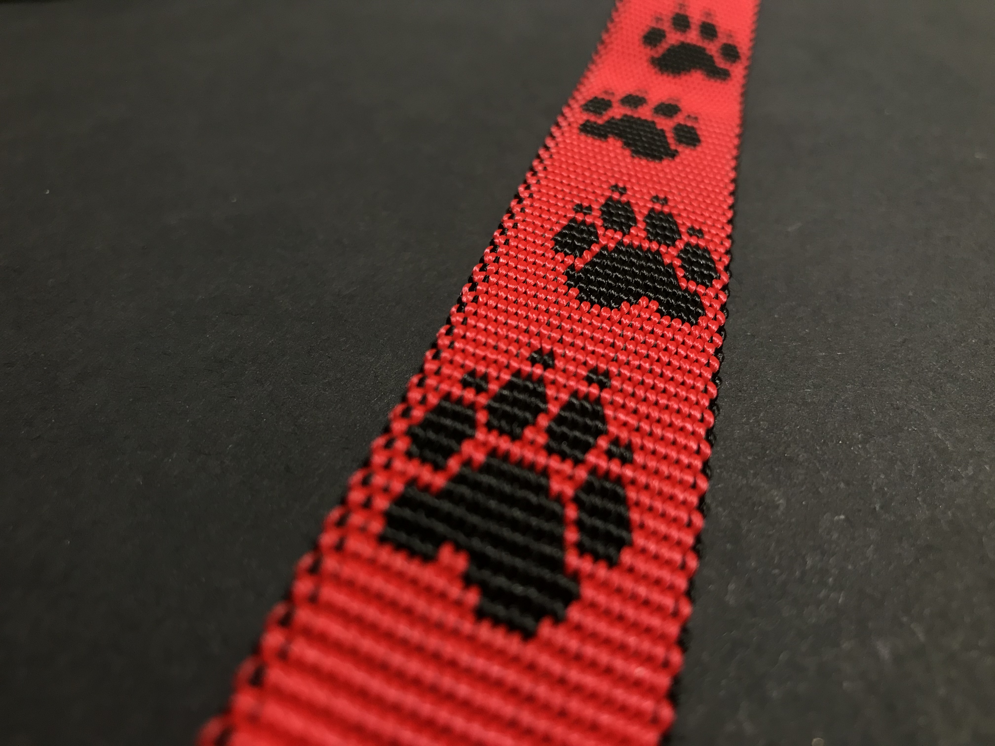 Palkar vodítko z popruhu pre psov 150 cm x 25 mm čierno-červená s labkami